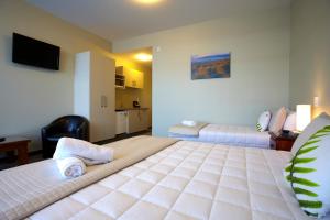 a hotel room with two beds and a television at Stumpers Hotel in Hokitika