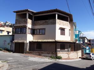 un edificio blanco con una puerta negra en una calle en Casa Triplex Arraial do Cabo, en Arraial do Cabo
