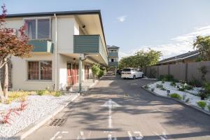 una calle frente a una casa con un coche aparcado en Central Park Motor Lodge, en Christchurch