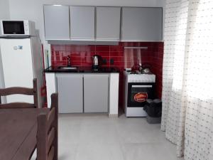 a small kitchen with white cabinets and a stove at Los cardenales 2 in Santa Ana