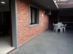 a room with a brick wall and tables and chairs at Los cardenales 2 in Santa Ana