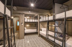 a room with three bunk beds and a clock at Sanim Hostel in Ao Nang Beach
