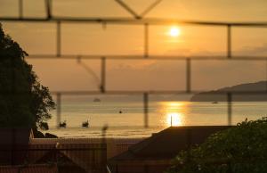 a sunset over the ocean with boats in the water at Sanim Hostel in Ao Nang Beach