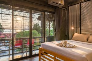 een slaapkamer met een bed en een groot raam bij Sanim Hostel in Ao Nang Beach