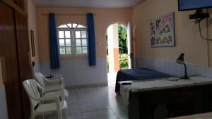 um quarto com uma cama, uma secretária e uma janela em Chalé Casa Factur em Fernando de Noronha