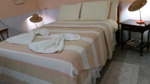 a hotel room with a bed with towels on it at Chalé Casa Factur in Fernando de Noronha