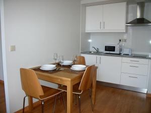 une cuisine avec une table en bois et des chaises ainsi qu'une salle à manger dans l'établissement 12 Short Term, à Porto