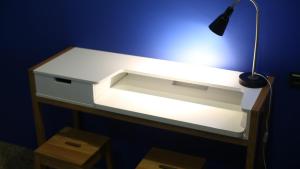 a white desk with a lamp on a blue wall at Drangar Country Guesthouse in Drangar
