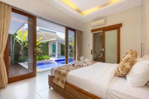 - une chambre avec un lit et une porte coulissante en verre dans l'établissement Bali Easy Living Canggu, à Canggu