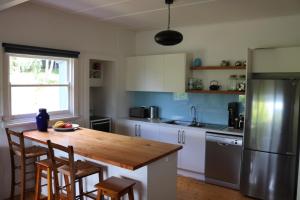 uma cozinha com uma mesa de madeira e um frigorífico em Lorne Haven em Lorne