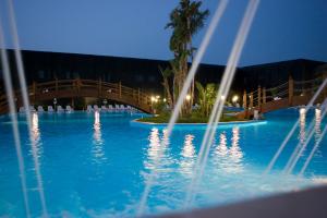 a swimming pool at night with a bridge over it at Hotel Roscianum Welness SPA in Rossano