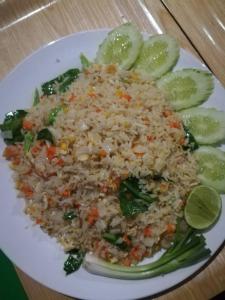 a white plate of rice and vegetables and lime slices at Chomlay Room & Restaurant in Ko Lanta