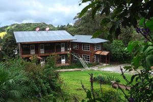 a large wooden house with a metal roof at Hotel Bosque Verde Lodge in Monteverde Costa Rica