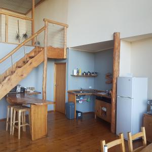 uma cozinha com uma escada, uma mesa e um frigorífico em Peppermint Ridge Retreat em Woodbridge