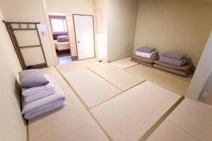 een lege kamer met 2 bedden en een spiegel bij Kanesuke Kyoto in Kyoto