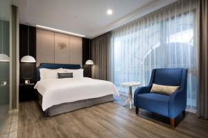 um quarto com uma cama grande e uma cadeira azul em 星鑽國際商旅 編號315 em Tainan