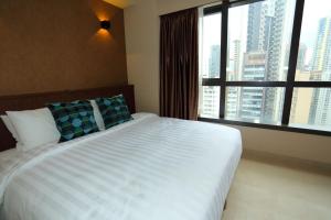 una camera da letto con un grande letto con una grande finestra di WE Hotel a Hong Kong