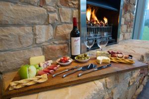 a table with wine and cheese and wine glasses at Bushland in Halls Gap +20 photos