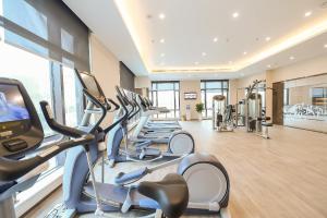 a gym with rows of treadmills and elliptical machines at Somerset Harmony City Wuxi in Wuxi