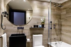 
a bathroom with a toilet, sink and mirror at Hotel Pamplona Plaza in Pamplona
