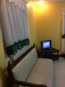 a room with a couch and a table with a television at Pines Mansion 2 Homestay Rooms for Rent in Cash with 30 percent Advance Payment to Confirm in Butuan