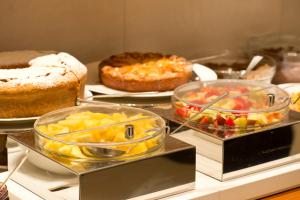 a buffet filled with pies and cakes and other foods at Hotel Spadari Al Duomo in Milan
