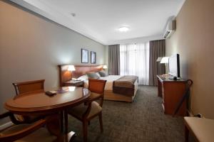 a hotel room with a bed and a table at Tucuman Center Suites&Business in San Miguel de Tucumán