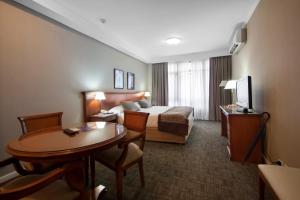ein Hotelzimmer mit einem Bett und einem Tisch in der Unterkunft Tucuman Center Suites&Business in San Miguel de Tucumán