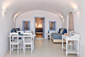 a living room with white tables and a couch at Anemomilos in Oia