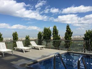 a balcony with two chairs and a swimming pool at Maison de Chine Taichung (Pin Chen) in Taichung