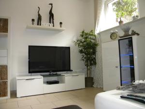 una sala de estar con TV de pantalla plana en un armario blanco en Ferienwohnung auf dem Land Schermbeck Moviepark, en Schermbeck