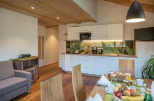 a kitchen and living room with a table with food on it at Hofer Hof in Feldthurns