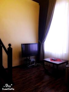 エッセントゥキにあるАпартаментыのリビングルーム(テレビ、テーブル、窓付)