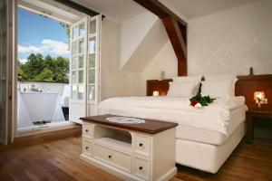 a bedroom with a bed and a table and a tub at Dwór Many, blisko do Suntago & DeepSpot in Many