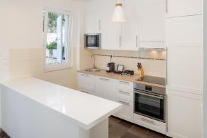 a kitchen with white cabinets and a counter top at Belado Residence Bol in Bol
