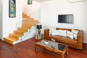 a living room with a leather couch and stairs at Belado Residence Bol in Bol