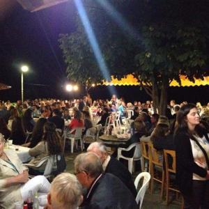 eine große Menschenmenge, die bei einer Veranstaltung auf Stühlen sitzt in der Unterkunft Natasa Rooms in Filippaioi