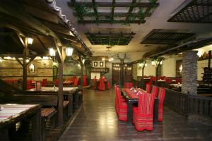 a restaurant with red chairs and tables in a room at Family Hotel Silistra in Silistra