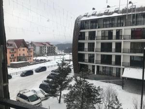a view of a parking lot with cars in the snow at Haystack Bakuriani in Bakuriani