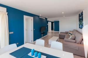 sala de estar con paredes azules, mesa y sofá en Ag Bahamas Premium, en Gandía