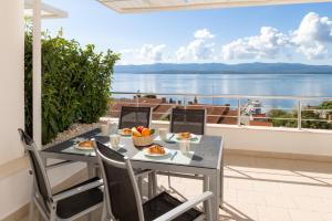 a table and chairs on a balcony with a view of the water at Belado Residence Bol in Bol