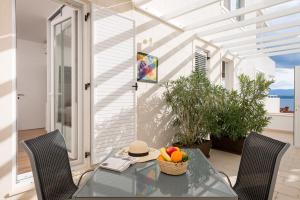 a glass table with a bowl of fruit on a patio at Belado Residence Bol in Bol
