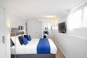 a bedroom with a bed with blue pillows and a tv at Guesthouse Prinsencanal 1 in Amsterdam