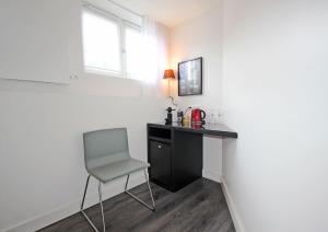 a desk and a chair in a room with a window at Guesthouse Prinsencanal 1 in Amsterdam