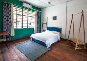 a bedroom with a bed and a green wall at The Jungalow in Kota Kinabalu