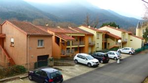 a group of cars parked in a parking lot next to houses at Eole in Amélie-les-Bains-Palalda