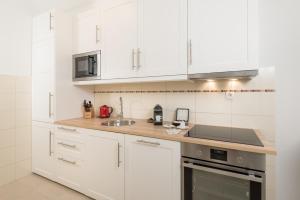 a white kitchen with white cabinets and a sink at Belado Residence Bol in Bol