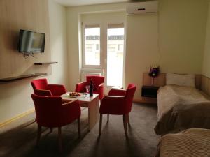 a room with a bed and a table and chairs at Apartments Mavesa in Vrnjačka Banja