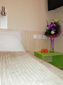 a bedroom with a bed and a vase with flowers on a table at Apartments Mavesa in Vrnjačka Banja +20 photos
