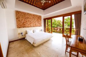 una camera da letto con un letto, una scrivania e finestre di Villa Suzuki 2 Seminyak a Seminyak Altre 43 foto